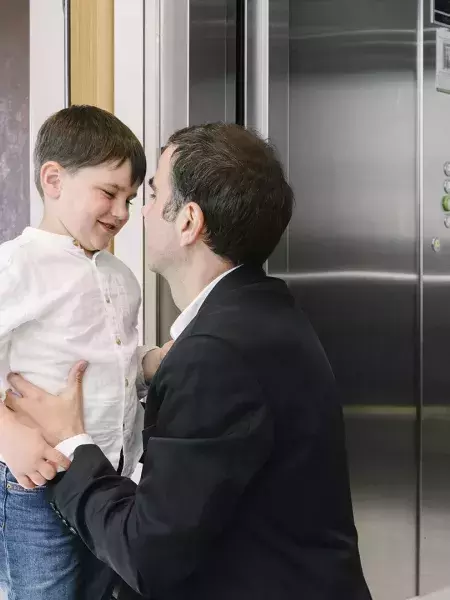 Vader en zoon op de overloop bij de Orona lift