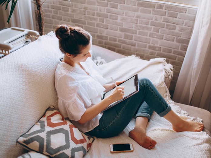 donna sul divano che naviga con l'ipad